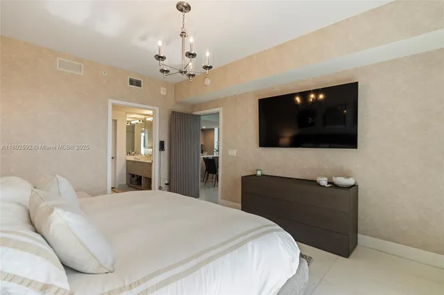 a bedroom with a bed window and a flat screen tv