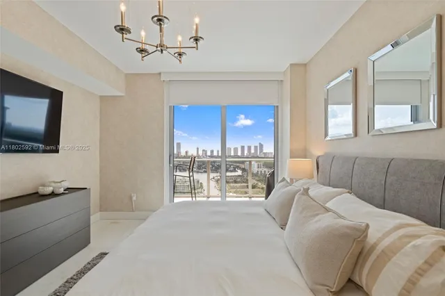 a bedroom with a bed and a flat tv screen on dresser