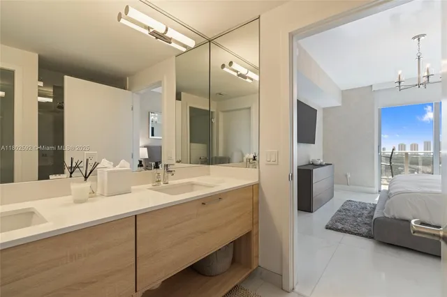 a en suite bathroom with a double vanity sink a mirror and a shower