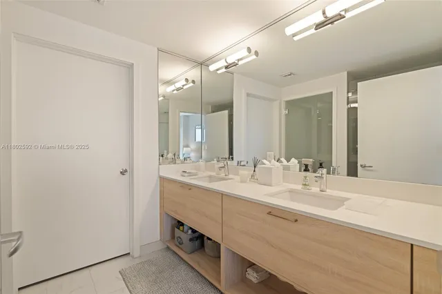 a bathroom with a double vanity sink mirror and