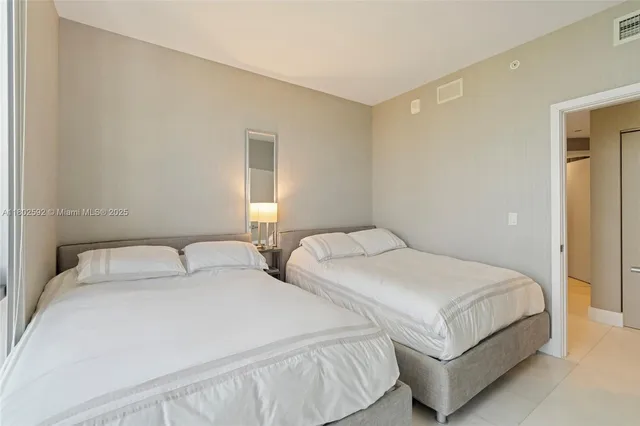 a bedroom with two beds and a night stand