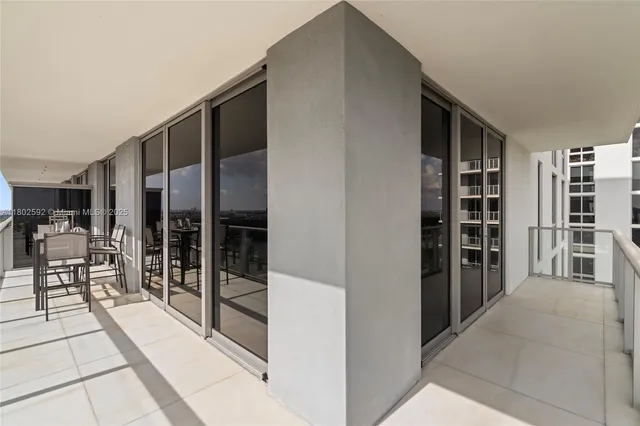 a view of a city from a balcony with outdoor seating