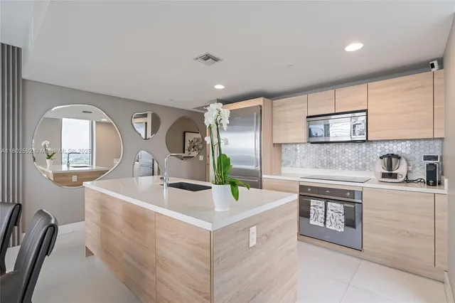 a kitchen with stainless steel appliances granite countertop a sink stove and cabinets