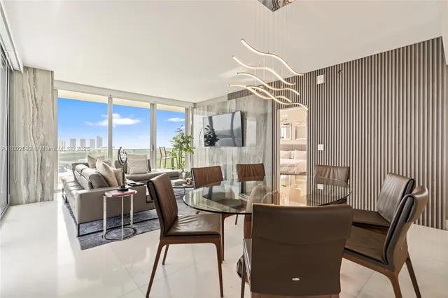 a dining room with furniture and a floor to ceiling window