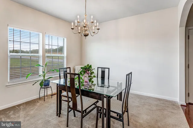 a view of a dining room with furniture a chandelier and wooden floor