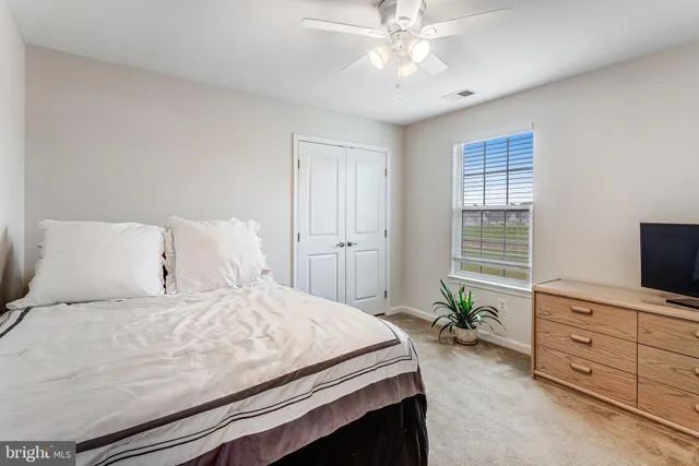 a bedroom with a large bed and a flat tv screen on dresser