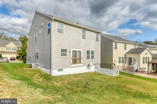 a view of a house with a yard and chairs
