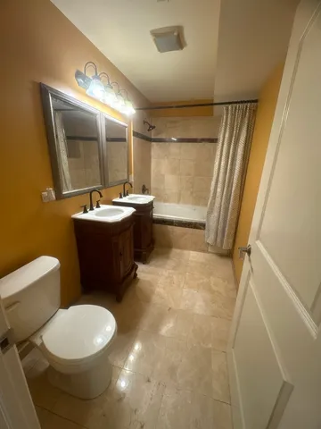a bathroom with a sink mirror vanity and toilet