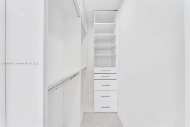 a spacious bedroom with a bed and a flat screen tv