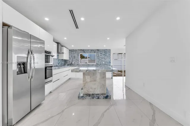 a kitchen with stainless steel appliances granite countertop a stove a sink and a refrigerator