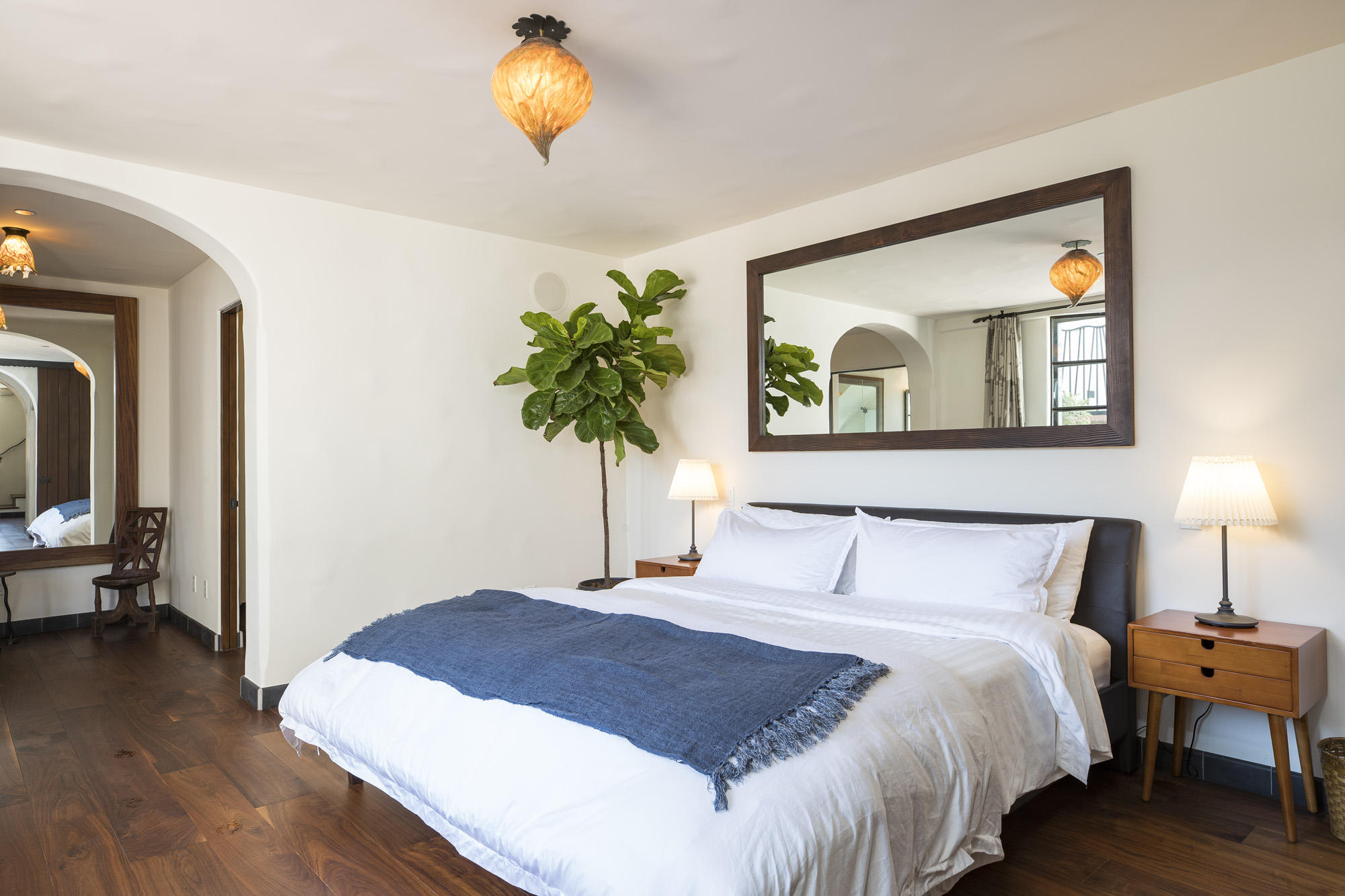 819 Garden Street Santa Barbara, CA 93101 - Photo 17 of 41 a bedroom with a bed and a chandelier