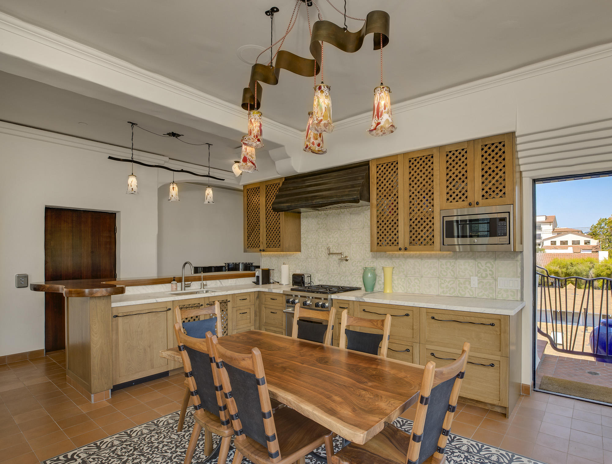 819 Garden Street Santa Barbara, CA 93101 - Photo 22 of 41 a kitchen with a table chairs refrigerator and microwave