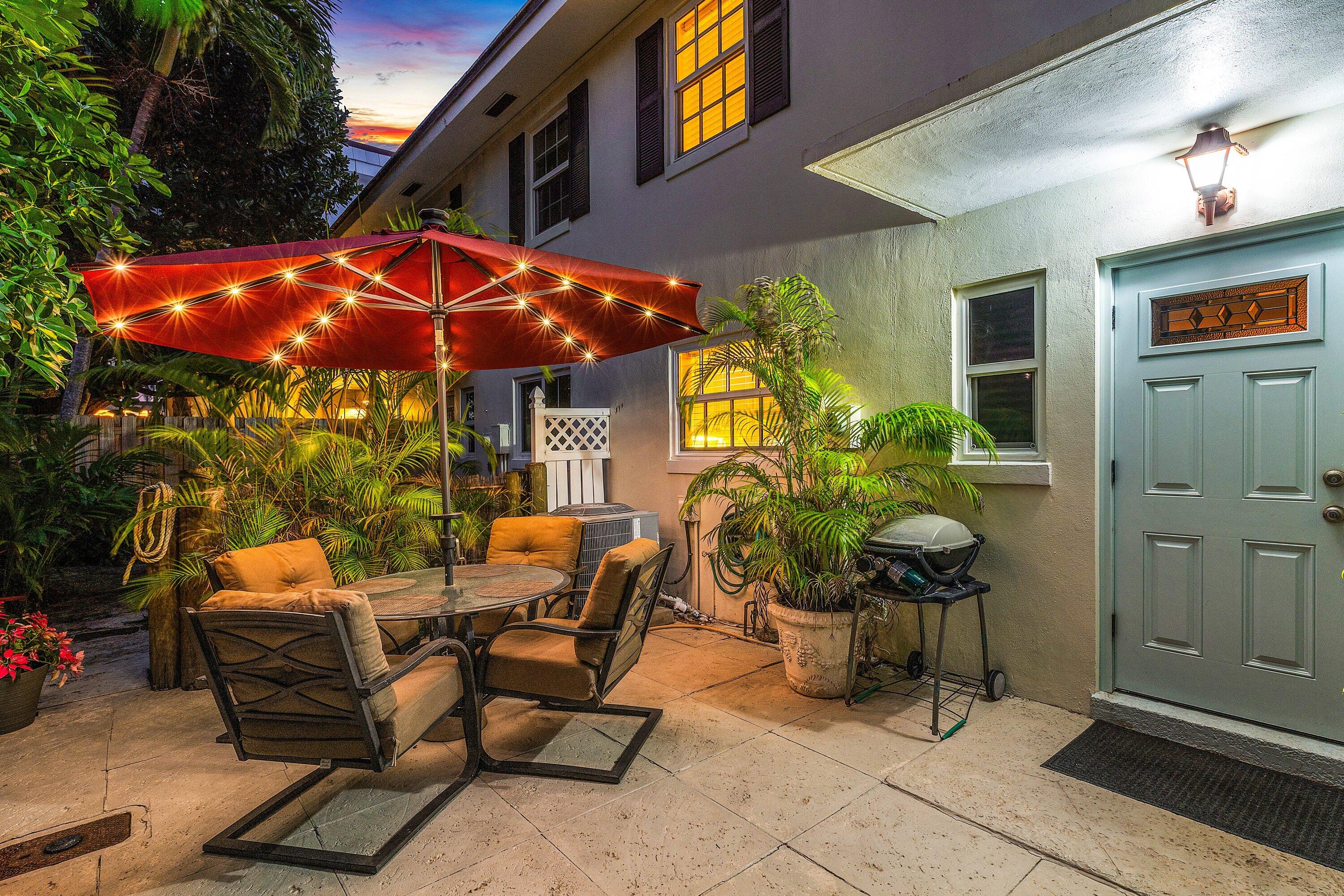 6590 North Ocean Boulevard, Unit 5 Ocean Ridge, FL 33435 - Photo 2 of 20 a view of a patio with table and chairs under an umbrella