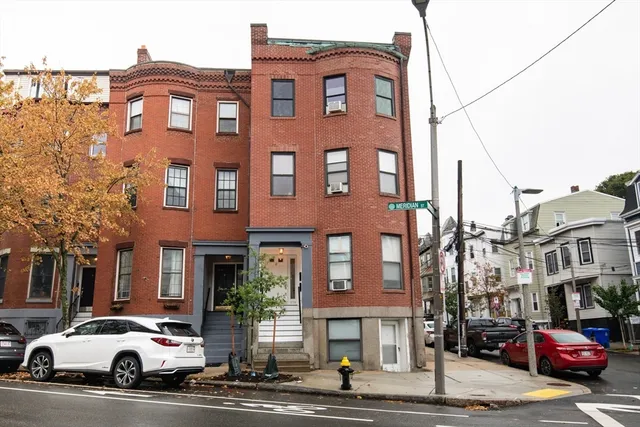 a couple of cars parked in front of brick building