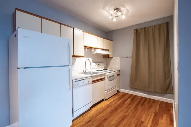 a kitchen with a refrigerator sink stove and cabinets