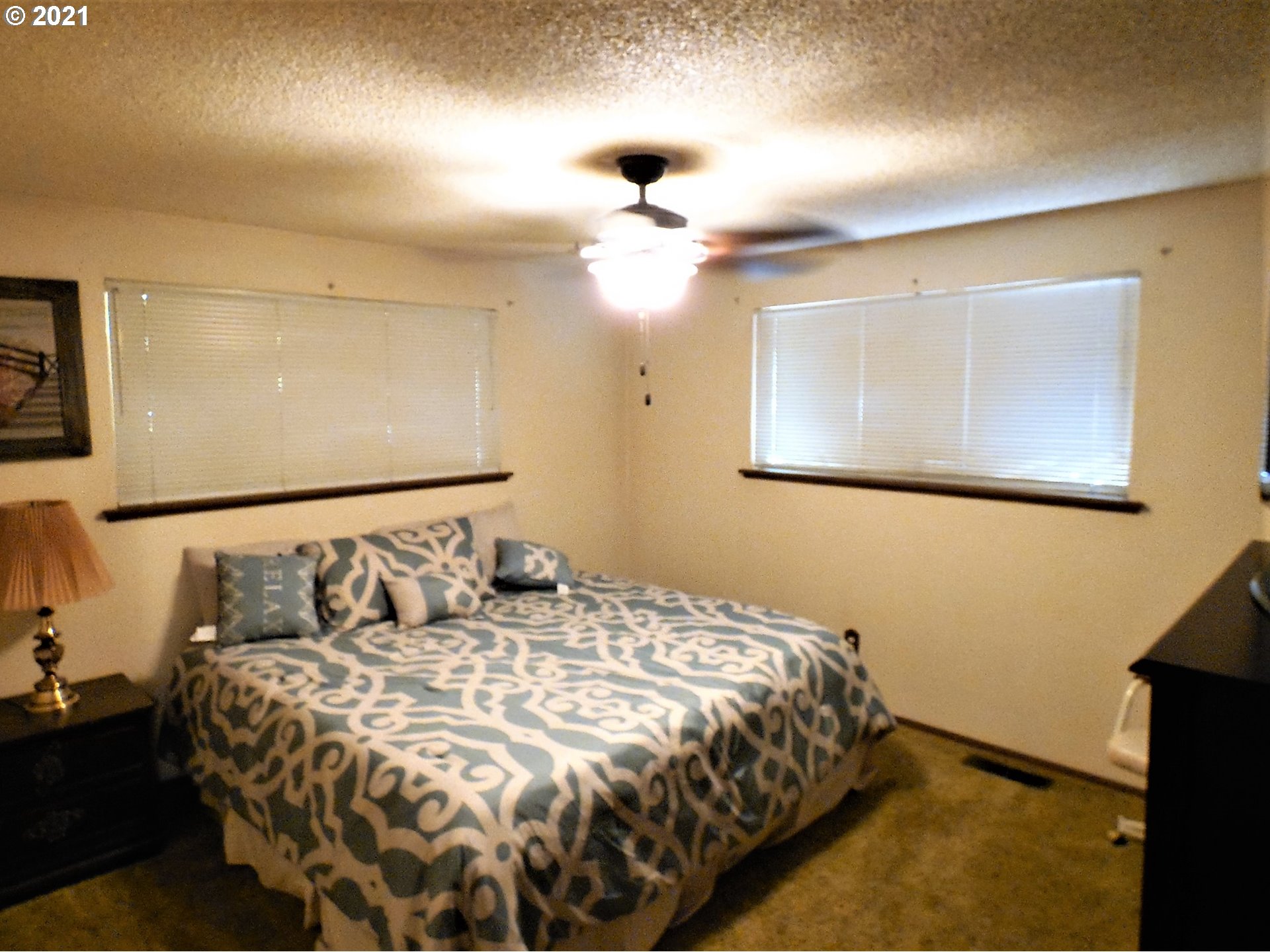 4235 Shoestring Road Riddle, OR 97469 - Photo 15 of 30 a bedroom with a bed and a chandelier