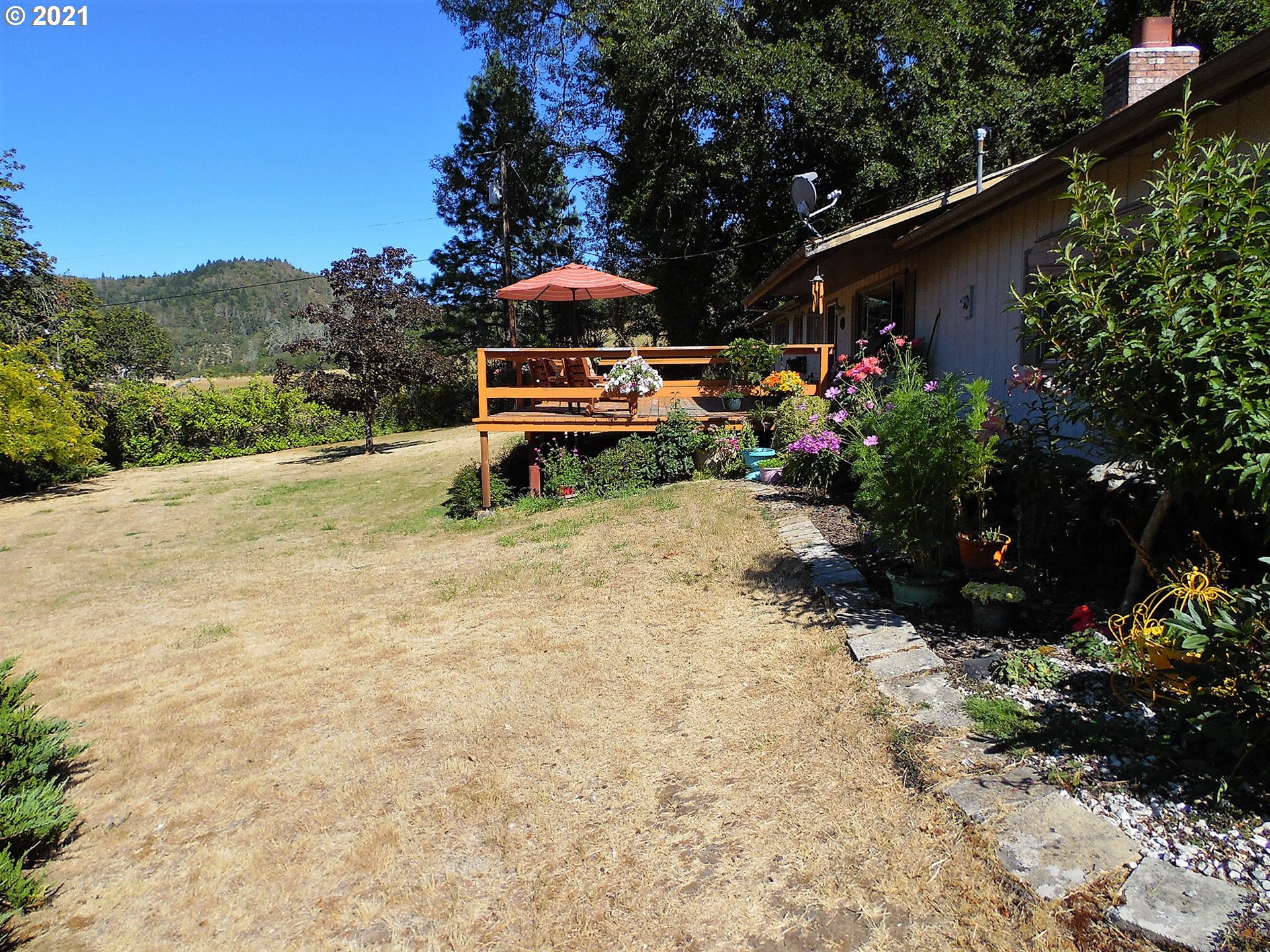 4235 Shoestring Road Riddle, OR 97469 - Photo 21 of 30 a view of a garden with plants and a bench
