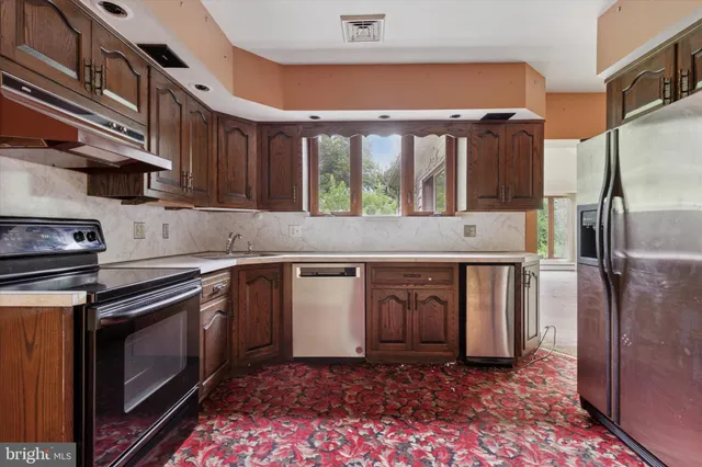 a kitchen with stainless steel appliances granite countertop a stove a sink and a refrigerator