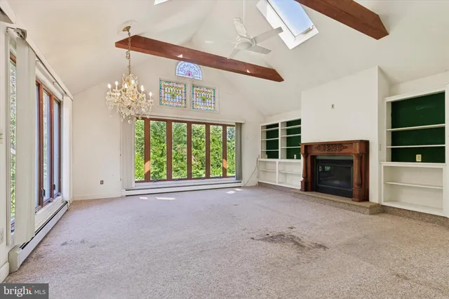 a view of an empty room with a fireplace and a window