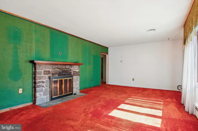 a view of an empty room with a fireplace and a window