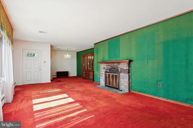 a view of an empty room with a fireplace and a window