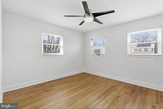 a view of a big room with wooden floor and windows