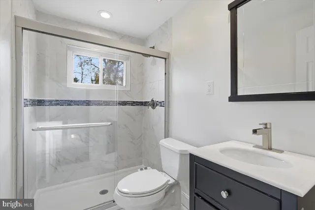 a bathroom with a toilet a sink and mirror