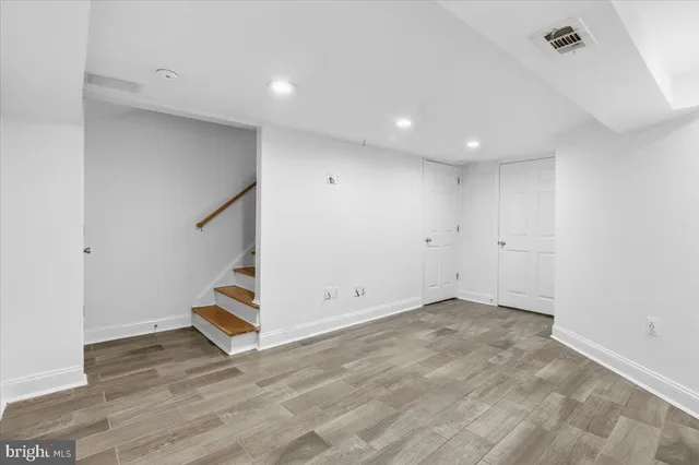 an empty room with wooden floor and white walls