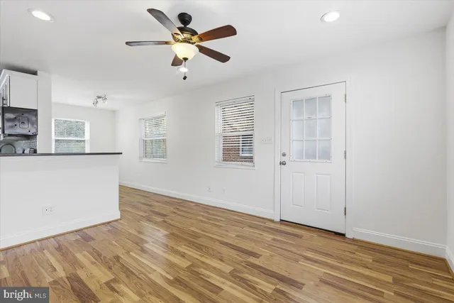 a view of a kitchen with wooden floor and a ceiling fan