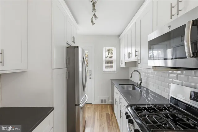 a kitchen with stainless steel appliances granite countertop a sink stove and refrigerator