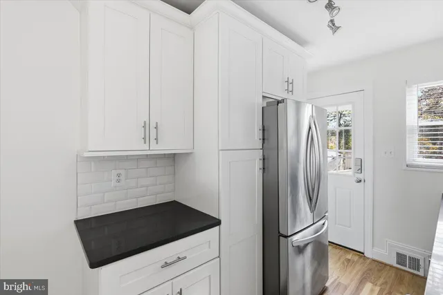 a kitchen with stainless steel appliances a refrigerator and a stove top oven