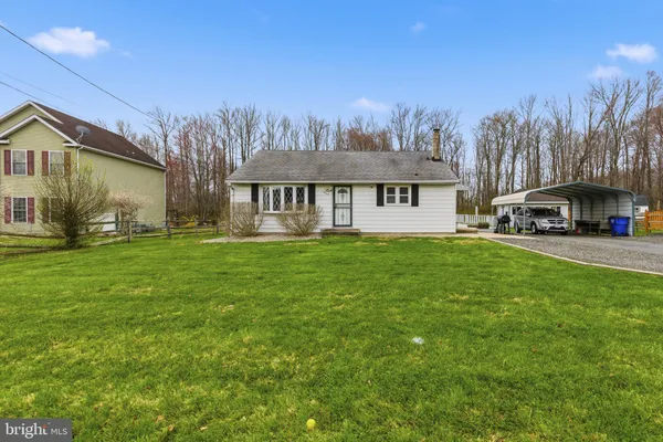 a front view of house with yard and trees