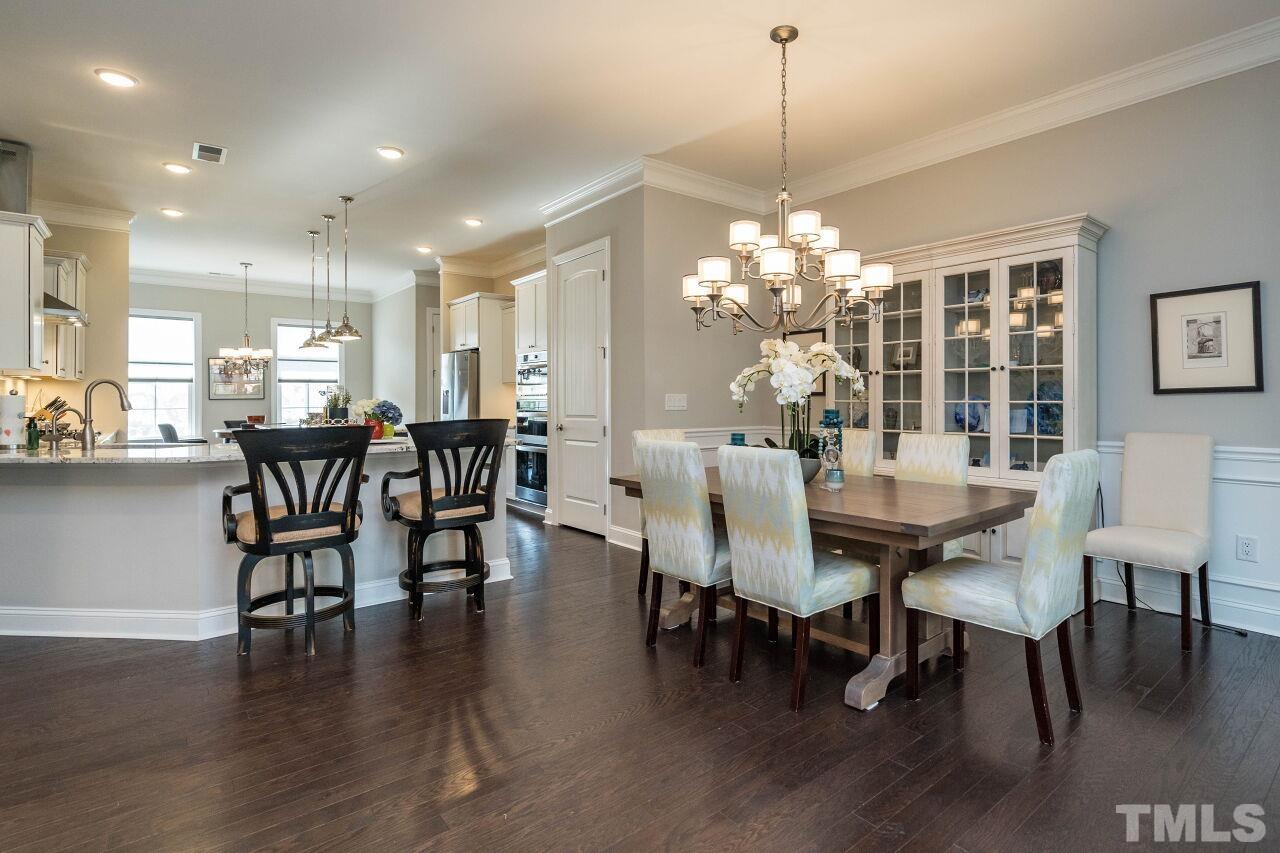 129 Damsire Way Cary, NC 27513 - Photo 11 of 32 a dining room with furniture wooden floor a chandelier and a painting
