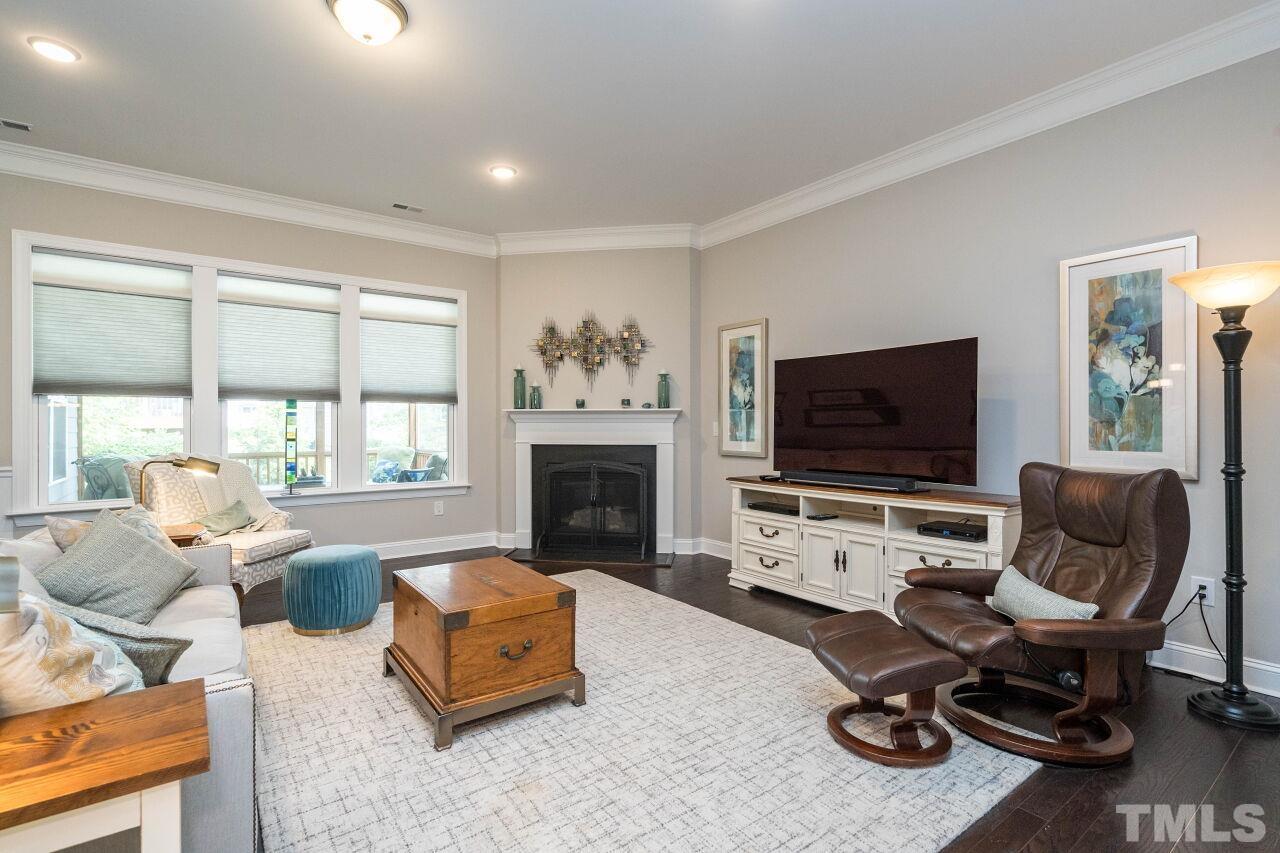 129 Damsire Way Cary, NC 27513 - Photo 13 of 32 a living room with furniture a flat screen tv and a fireplace