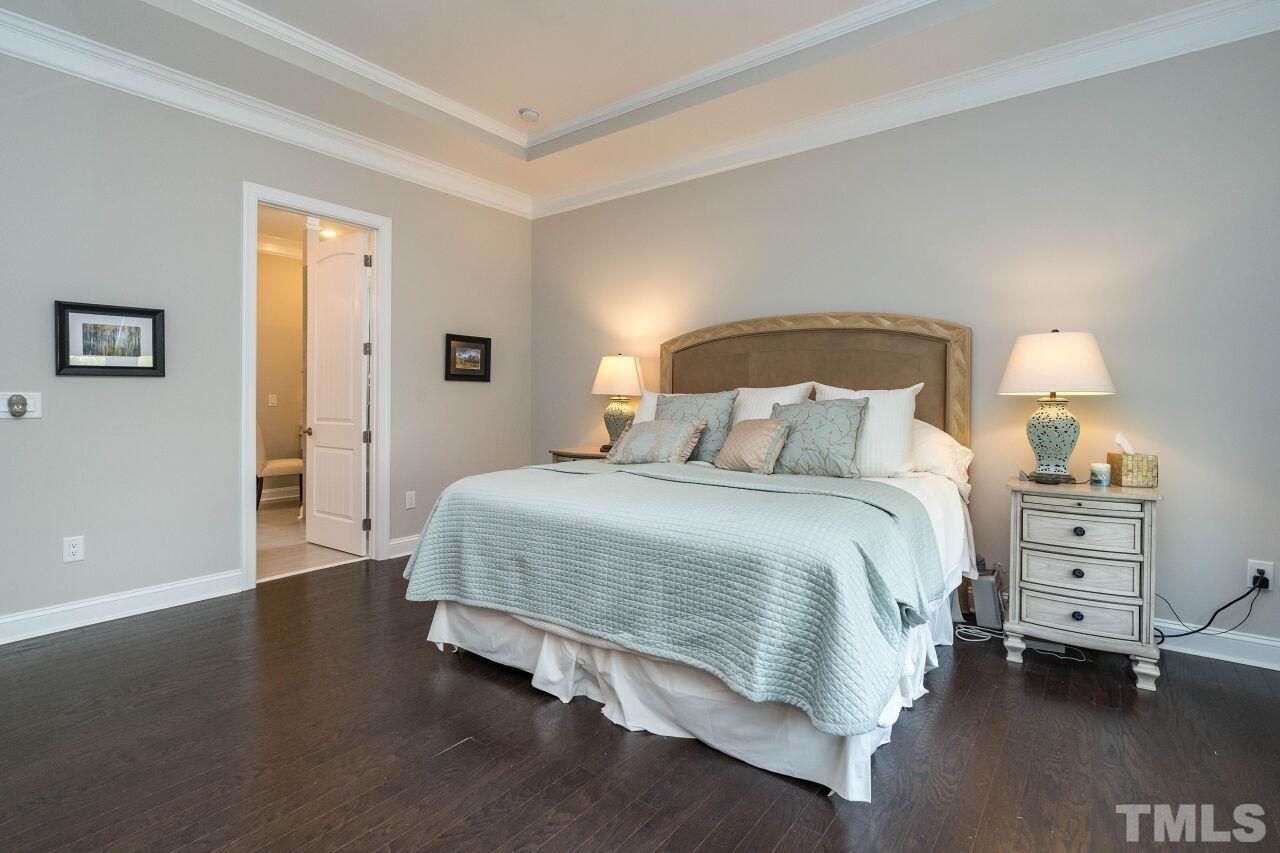 129 Damsire Way Cary, NC 27513 - Photo 20 of 32 a spacious bedroom with a bed and a lamp