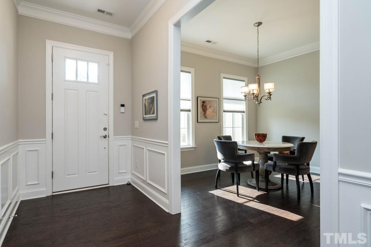 129 Damsire Way Cary, NC 27513 - Photo 3 of 32 a view of a dining room with furniture a chandelier and wooden floor
