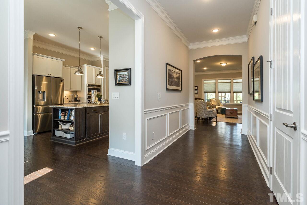 129 Damsire Way Cary, NC 27513 - Photo 4 of 32 a view of a hallway with wooden floor and a kitchen