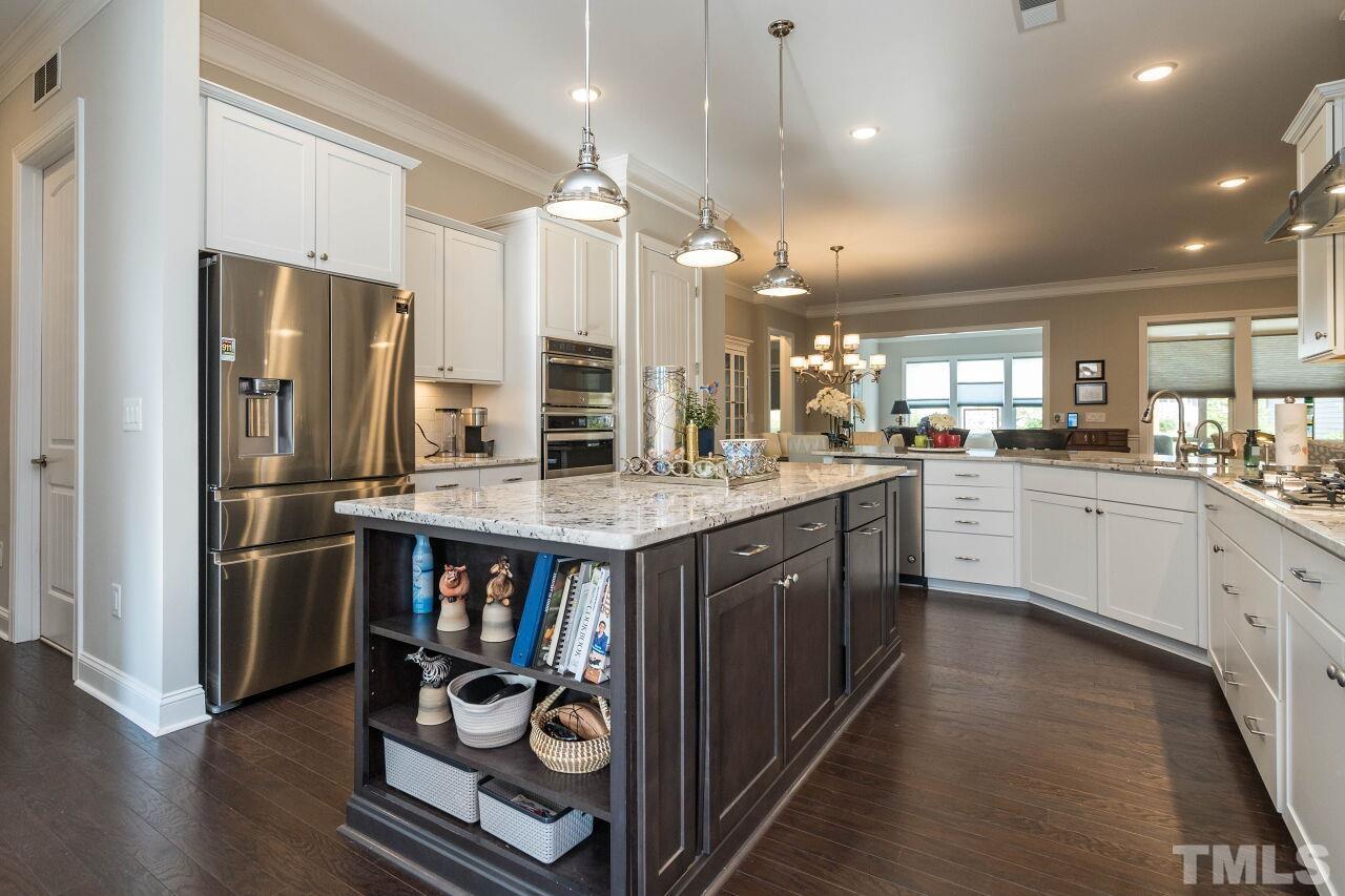 129 Damsire Way Cary, NC 27513 - Photo 6 of 32 a kitchen with stainless steel appliances granite countertop a refrigerator a sink dishwasher a stove and white cabinets with wooden floor