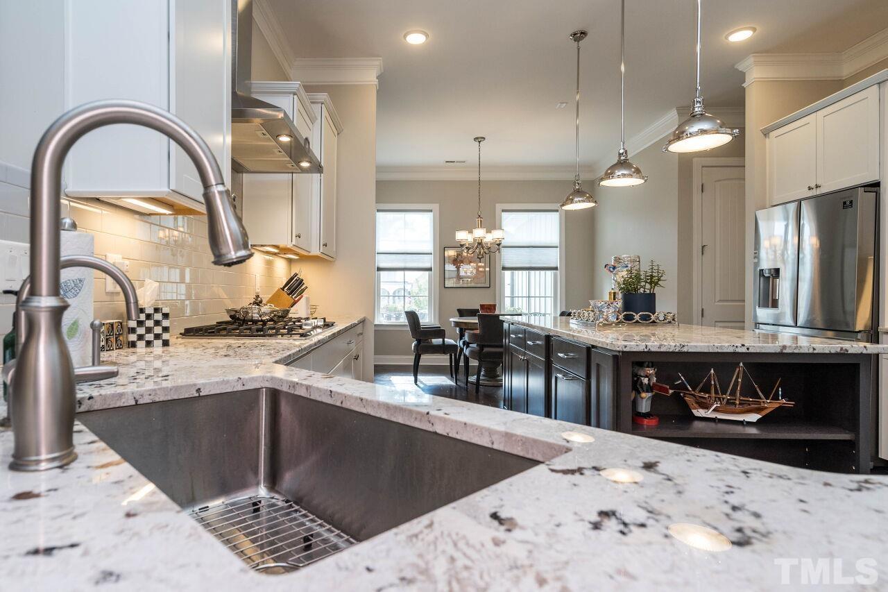 129 Damsire Way Cary, NC 27513 - Photo 9 of 32 a kitchen with stainless steel appliances kitchen island a large stove a sink a refrigerator and a sink