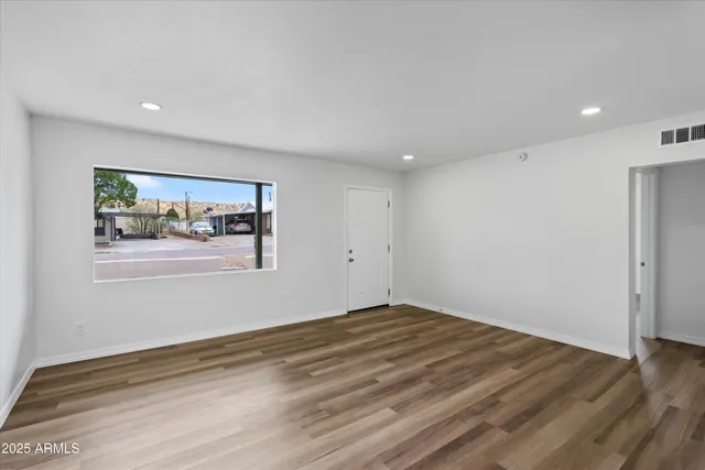 a view of empty room with wooden floor