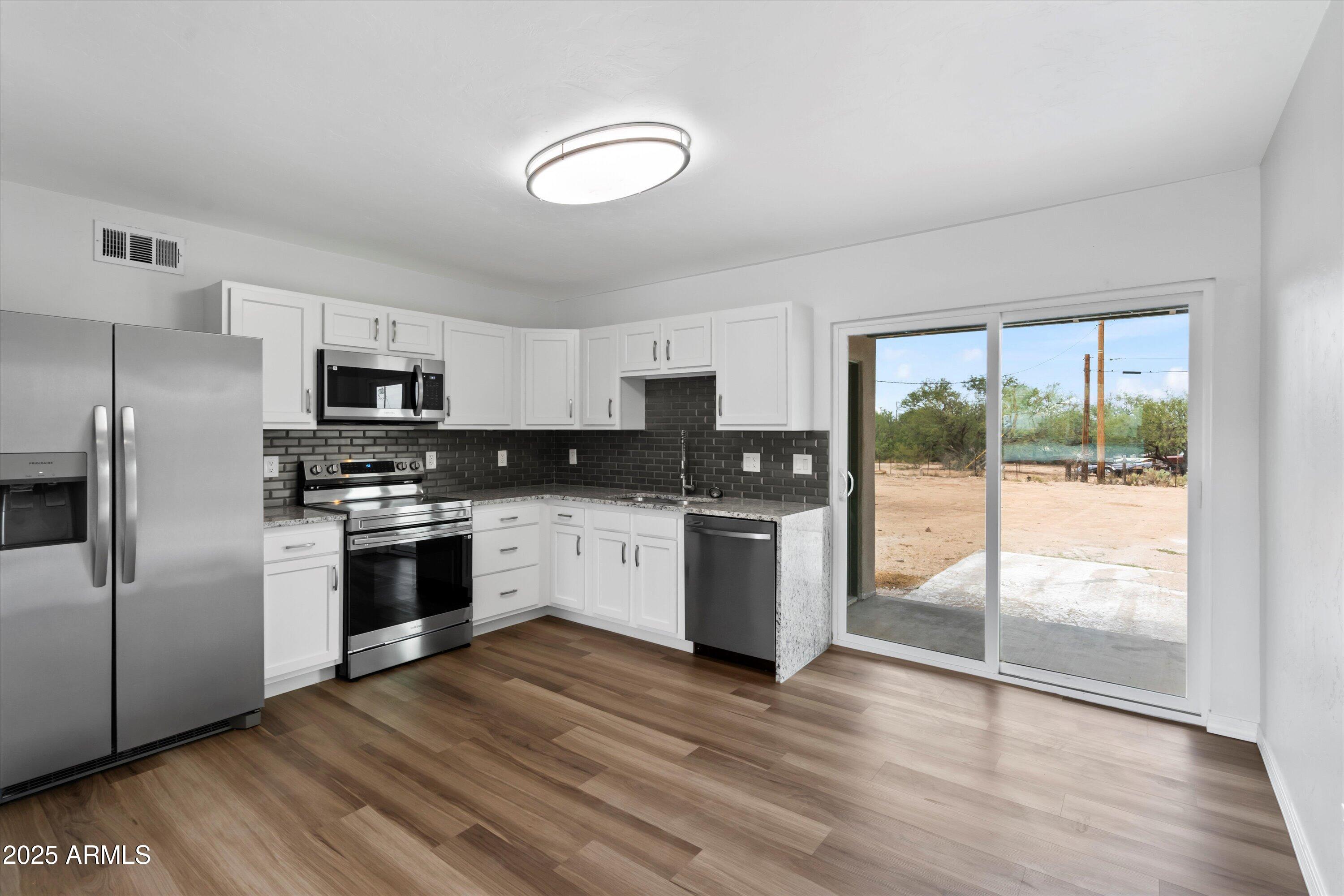 468 West Duane Street Benson, AZ 85602 - Photo 7 of 21 a kitchen with granite countertop a refrigerator stove top oven and sink