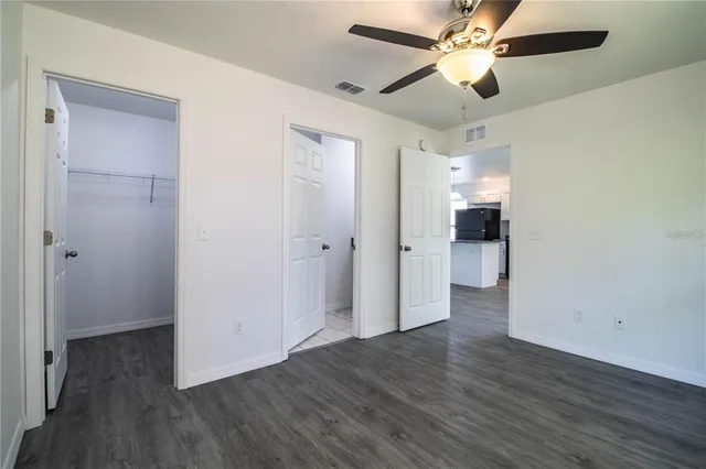 a view of a livingroom with a ceiling fan and wooden floor