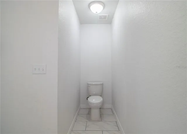 a bathroom with a granite countertop toilet and a sink