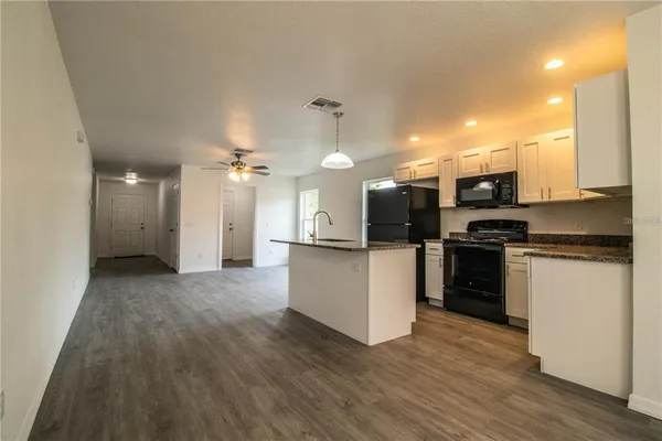 a kitchen with a refrigerator and a stove top oven