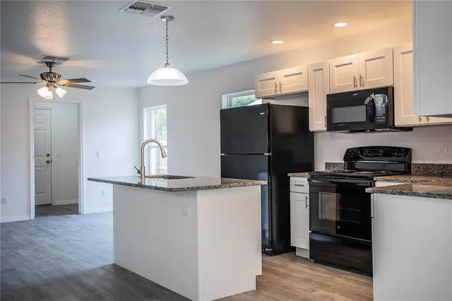 a kitchen with stainless steel appliances granite countertop a refrigerator a stove a sink and a granite counter tops