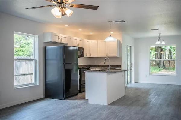 a kitchen with stainless steel appliances granite countertop a refrigerator a sink a stove a refrigerator and island