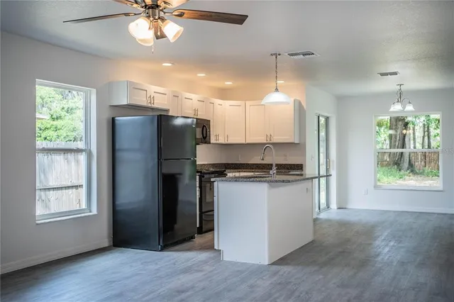 a kitchen with stainless steel appliances granite countertop a refrigerator a sink a stove a refrigerator and island