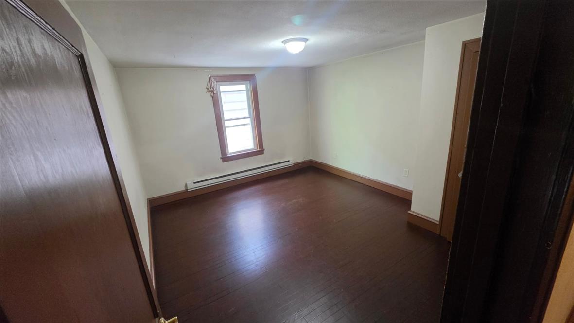233 East Ridge Street Lansford, PA 18232 - Photo 5 of 10 A well-lit bedroom features rich hardwood flooring and a single window.