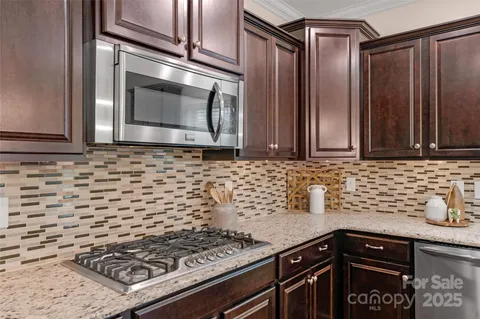 a kitchen with granite countertop a sink stove and cabinets