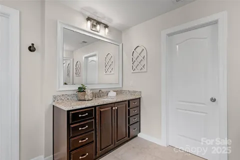 a bathroom with a granite countertop sink and a mirror